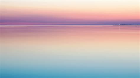 A Peaceful And Serene Pastel Pink And Purple Sunset Reflecting On Still