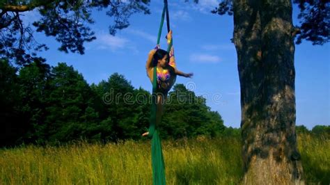 A Slender Girl With Dark Hair In A Beige Suit Performs Gymnastic And