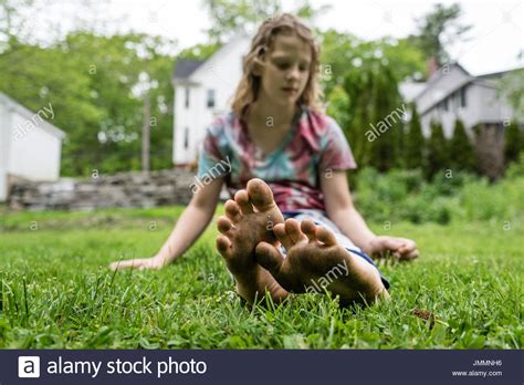 A Girl With Dirty Feet Sits In The Grass Stock Photo 150432050 Alamy