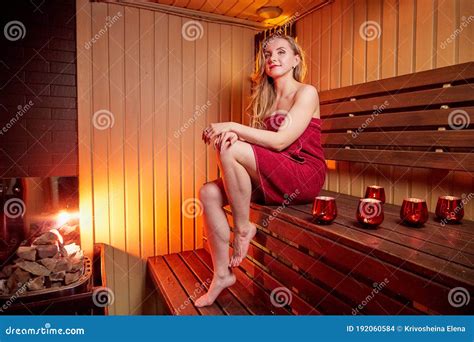 Beautiful Girl On Wooden Bench At Sauna In Steam Room With Nice Light