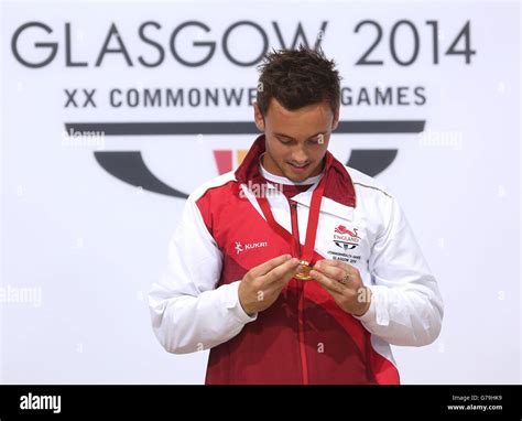 Englands Tom Daley Looks At His Gold Medal After Winning The Diving