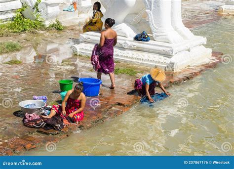 People Bathing And Washing On The Riverbank Of Irrawaddy River Next To