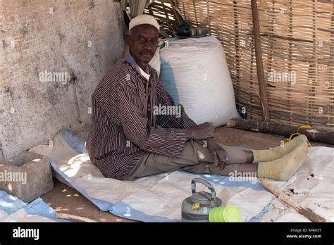 An Ethnic Mandinka Mandingo Man Shelters From The Midday Sun In His