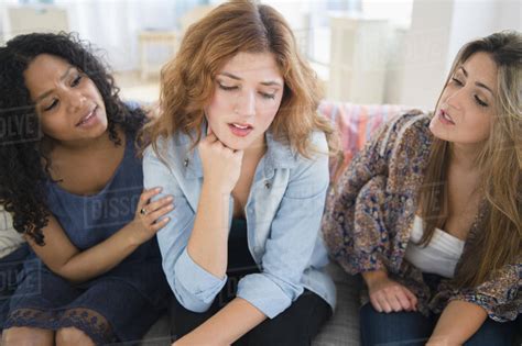 Women Comforting Sad Friend On Sofa In Living Room Stock Photo Dissolve