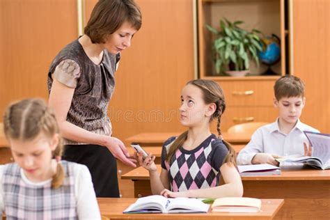 Teacher Confiscating Mobile Phone At Lesson In School Stock Photo