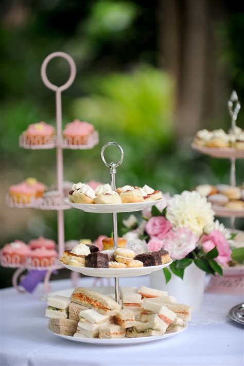 Three Tiered Trays With Cupcakes And Pastries On Them Sitting On A Table