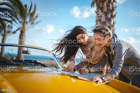 Young Hipster Women With Retro Convertible Car Reading Road Map Stock