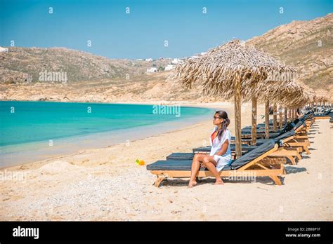 Woman Vacation Mykonos Beach During Summer With Umbrella And Luxury