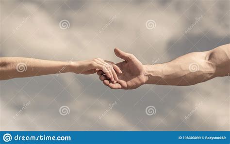 Giving A Helping Hand Hands Of Man And Woman On Blue Sky Background