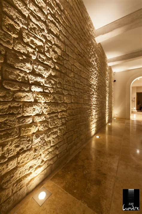 Des spots au sol pour mettre en valeur ce mur en pierre. http://www