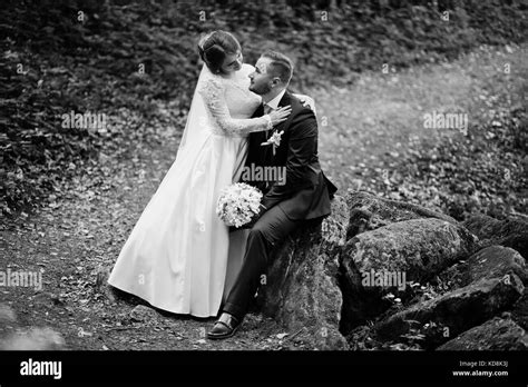 Magnificent Bride Sitting On A Lap Of Her Husband In The Forest On A