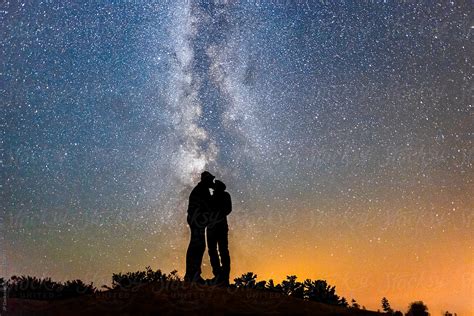 Silhouette Of Couple Kissing Under Milky Way Galaxy Night Sky By