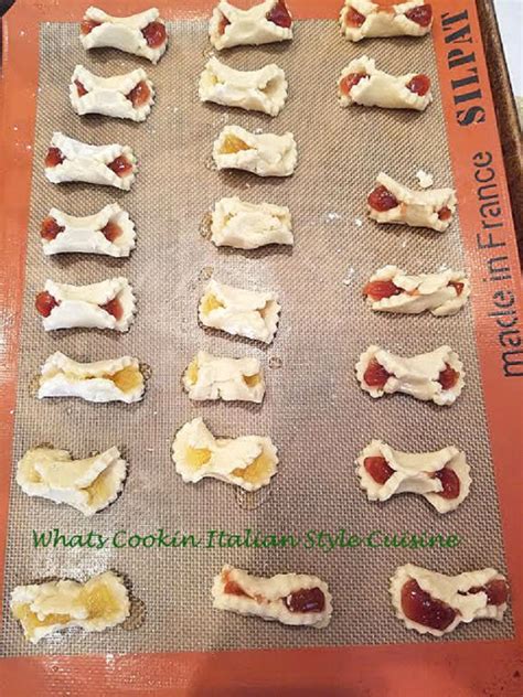 These thumbprint cookies are buttery treats with the tartness of raspberry and lemons. Jam Filled Bow Tie Cookies | What's Cookin' Italian Style Cuisine