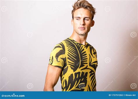 Elegant Young Handsome Man In Yellow T Shirt Studio Portrait Stock