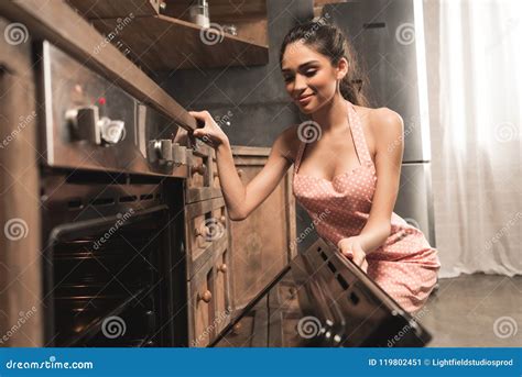 Giovane Donna Sexy Nel Forno E Nel Sorridere Di Apertura Del Grembiule