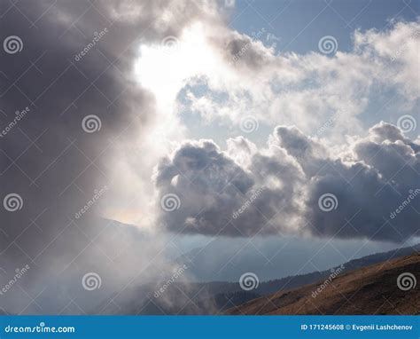 View Of Blue Sky Clouds And Mountains Through A Light Misty Haze Stock