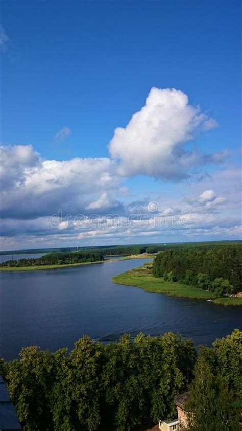 Blue Sky And Blue Lake In Summer White Clouds Are Reflected In The