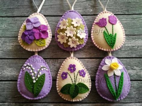 Four Felt Easter Eggs Decorated With Flowers And Daisies On A Wooden