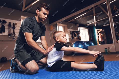 Premium Photo Father And Son Are Stretching Each Other In Gym