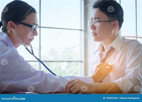 Senior Female Doctor Consults Young Patient Sitting At Doctor Of Stock