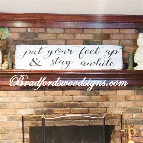 A Fireplace With A Sign Above It That Says Put Your Feet Up And Stay Awhile