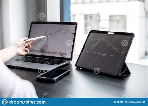 Stock Investor Holding A Pen Pointing A Tablet Screen That Opens A