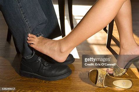 feet touch under table photos and premium high res pictures getty images