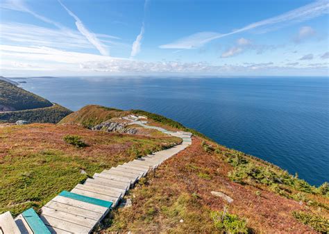 Stairs Lead Down To The Top Of A Grassy Hill Overlooking The Ocean On A