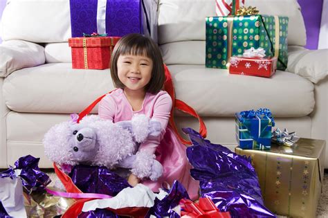 무료 Girl Unwrapping Present To Reveal Stuffed Dog 스톡 사진 Freeimages