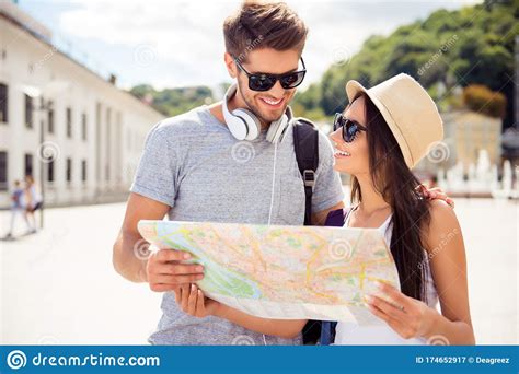 Happy Young Couple Of Travellers Holding Map In Hands Stock Image