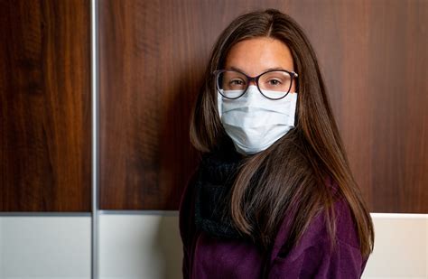 Portrait Of Beautiful Young Woman Wearing Surgical Mask And Eyeglasses During Pandemic Stock
