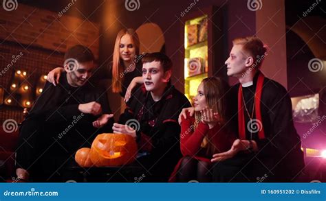 Young People In Costumes Are Celebrating Halloween In Cafe Stock