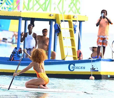 Rihanna Showcases Her Curves In A Flame Coloured Swimsuit As She Paddle Boards In Barbados