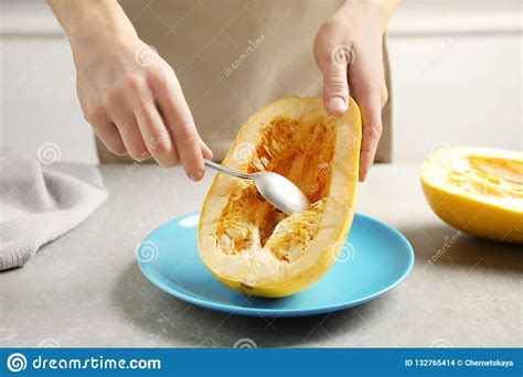Woman Scraping Flesh Of Spaghetti Squash With Spoon Stock Photo Image