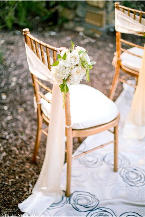Two Chairs With White Flowers On Them Are Set Up For An Outdoor