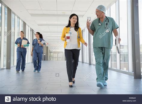 Surgeon Doctor And Nurses Talking And Walking In Hospital Corridor