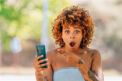 girl with mobile phone and expression of surprise or astonishment outdoors stock image image