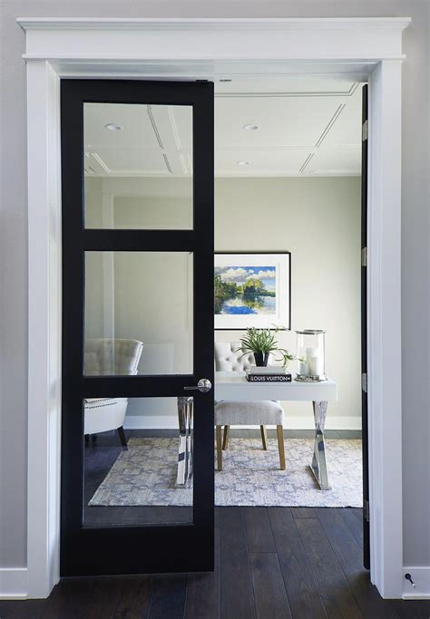Black French Doors Leading Into An Office With Paneled Wood Ceiling