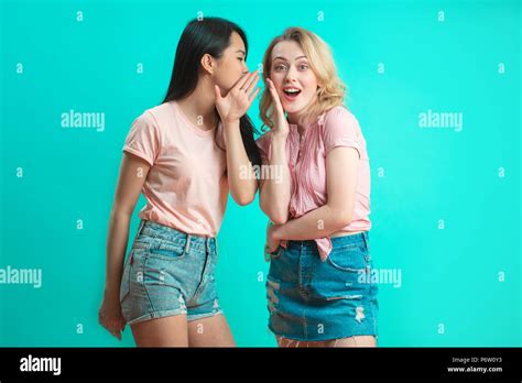 Young Asian Woman Telling Her Blonde Girlfriend Some Secret Two Women