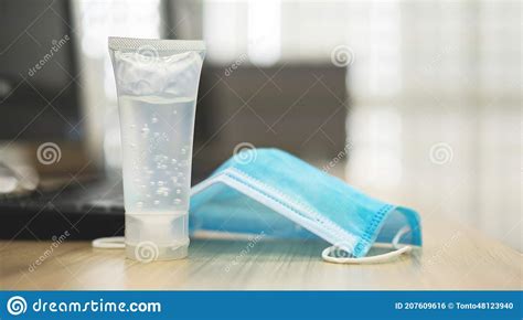 Alcohol Hand Sanitizer And Medical Surgical Masks On Work Desk Stock