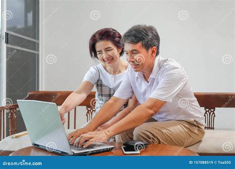 Middle Aged Asian Couple Using Laptop At Home Stock Image Image Of Asian Husband 157088519