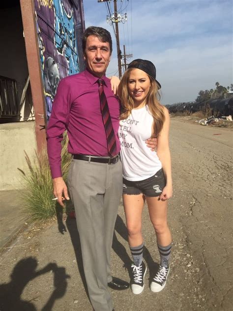 A Man Standing Next To A Woman In Front Of A Graffiti Covered Wall And