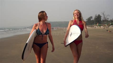Two Women Surfers In Bikinis Walk Along The Beach With Surfboards Stock Footage Video Of