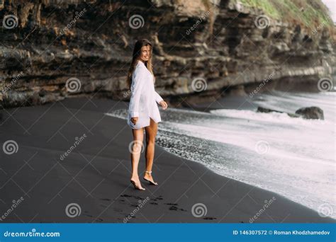 Jeune Fille Sexy Dans La Chemise Blanche Et Le Maillot De Bain Se Reposant Sur La Plage Noire De