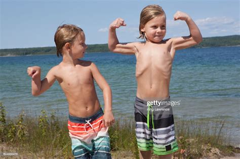Caucasian Boys Flexing Muscles On Beach High Res Stock Photo Getty Images