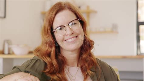 Woman Wearing Headphones With Microphone Sits On A Bed And Works Remotely From Her Cozy Bedroom