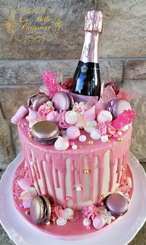 A Pink Cake With Frosting And Decorations On It Next To A Bottle Of