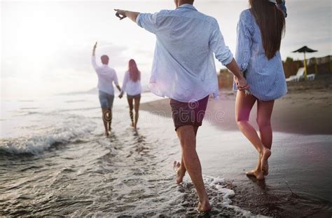 Friends Having Fun On The Beach Under Sunset Sunlight Stock Image