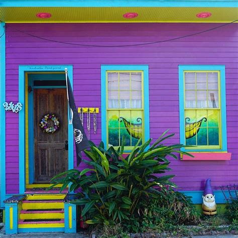 A Purple House With Bright Blue Windows And Yellow Steps Leading Up To