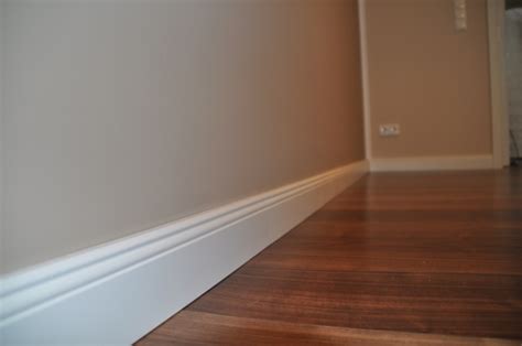 Lässt es die aufbauhöhe zu, können unebene fliesenböden mit ausgleichsmasse egalisiert werden. Weisse Sockelleisten im Landhaus-Stil auf dunklem Laminat ...